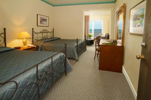 マタンにあるHotel Motel Belle Plageのベッド2台とデスクが備わるホテルルームです。