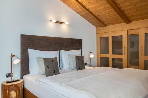 a bedroom with a large bed with white sheets and pillows at Ritschhof in Laion