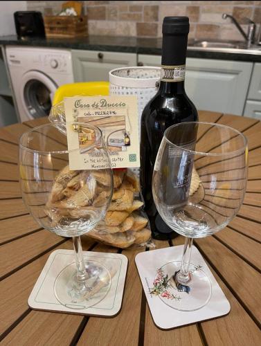a table with two wine glasses and a bottle of wine at Casa di Duccio in Montone