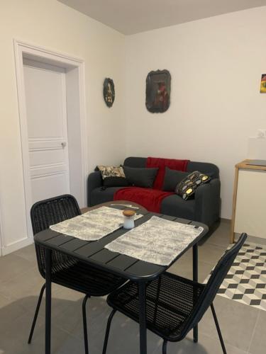 Appart ROSA في شاتوه غونتير: طاولة وكراسي في غرفة معيشة مع أريكة