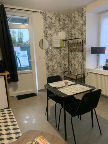 d'une salle à manger avec une table, des chaises et une fenêtre. dans l'établissement Appart ROSA, à Château-Gontier