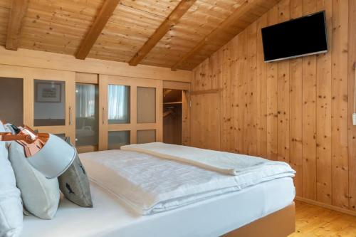 a bedroom with a bed and a tv on a wooden wall at Ritschhof in Laion