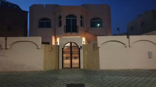una casa con una puerta delante de un edificio en Budget Backpackers Hostel, en Abu Dabi