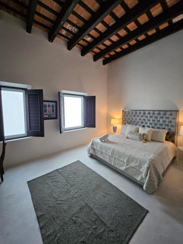 a bedroom with a bed with two windows and a rug at KASA San Francisco 2 in San Juan