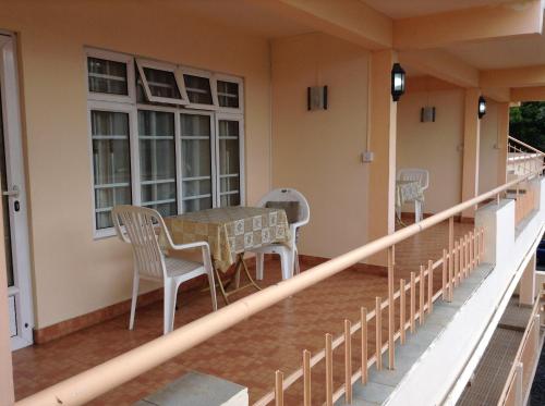 a balcony of a house with a table and chairs at Ebrahim Flats - Grand Baie Beach in Grand Baie
