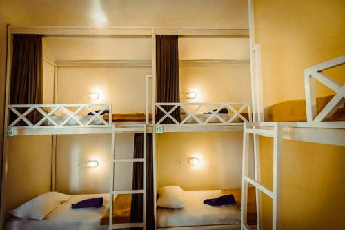 a room with three bunk beds in it at The Commotion Canggu in Dalung