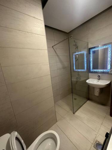 a bathroom with a shower and a toilet and a sink at cozy home near all services (19) in Rujm ash Sharāʼirah