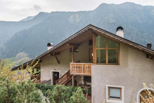 ein Haus mit einer Terrasse und Bergen im Hintergrund in der Unterkunft Ritschhof in Lajen