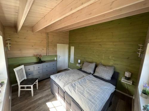 a bedroom with a bed and a wooden wall at Idyllisches-Blockbohlenhaus-mit-eigenem-Garten-und-Sauna-zum-Wohlfuehlen in Martensrade