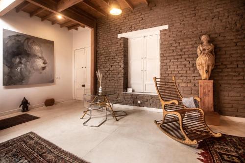 a room with a brick wall and two chairs and a statue at Villa with Rooftop Terrace in Barranco in Lima