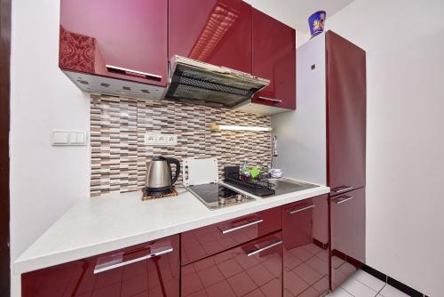 a kitchen with red cabinets and a counter top at Destiny apartment in Bratislava