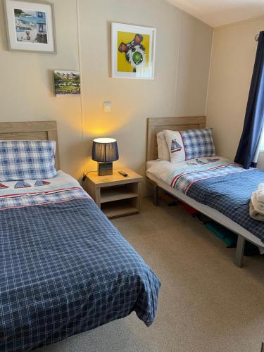 a bedroom with two beds and a lamp on a table at Nodes Point Sandy Bay AP27 affordable ferry prices available in Saint Helens