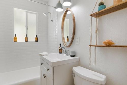 a bathroom with a toilet and a sink and a mirror at Audreys Place - Hot tub - Fire Pit - Downtown JT in Joshua Tree