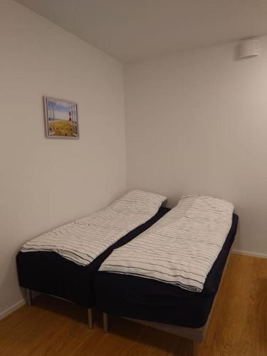 two beds in a room with a white wall at New AC Studio City Center. in Turku