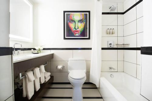 La salle de bains est pourvue de toilettes blanches et d'un lavabo. dans l'établissement Park Central, à New York