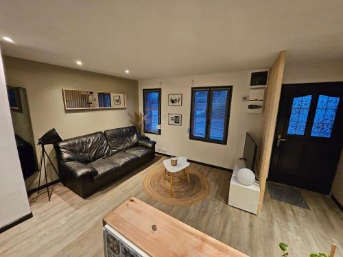 sala de estar con sofá de cuero y mesa en ENTRE 2 VAGUES en Mers-les-Bains