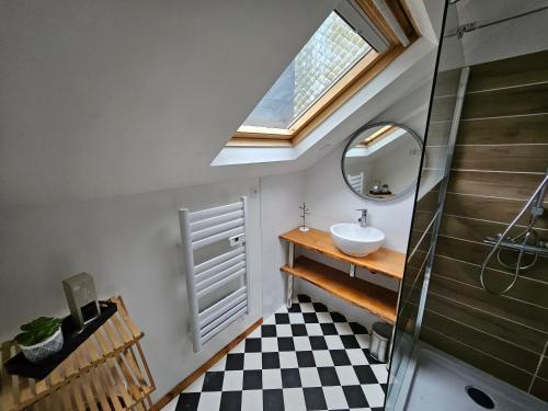 een badkamer met een wastafel en een dakraam bij ENTRE 2 VAGUES in Mers-les-Bains