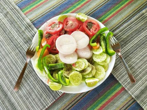a plate of vegetables on a table with two forks at kannur west beach homestay in Kannur