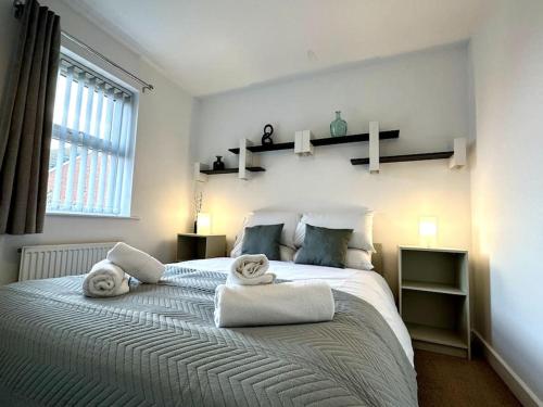 a bedroom with a large bed with towels on it at Dale House by Blue Skies Stays in Middlesbrough