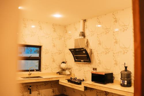eine Küche mit einer Theke, einer Spüle und einer Mikrowelle in der Unterkunft Billiards And Karaoke, Free Pickup in Sengkuang