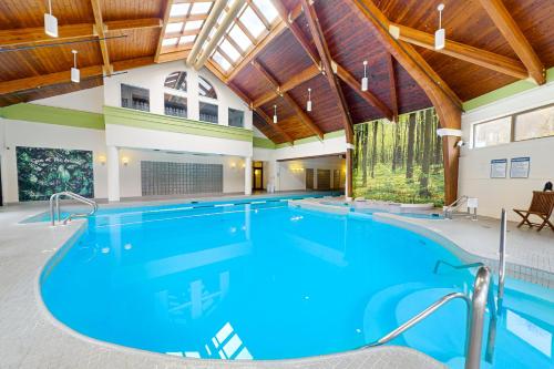 una grande piscina coperta con acqua blu in un edificio di The Woods: Village-11 a Killington