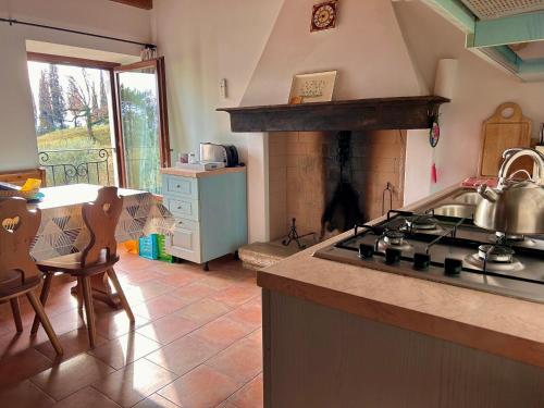 a kitchen with a stove and a kitchen with a table at Agriturismo Cervano in Toscolano Maderno