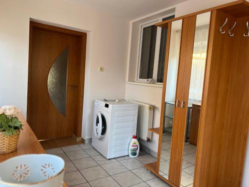a laundry room with a washer and dryer next to a door at Amma House Timisoara in Timişoara
