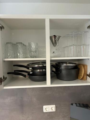 a kitchen shelf with pots and pans and utensils at Neu Ⅰ Ⅰ 2-Zimmer Ⅰ Zentrumslage Ⅰ Schwabach Ⅰ Nürnberg Ⅰ Roth in Schwabach