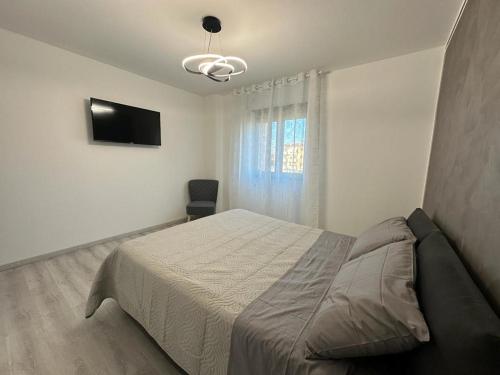 a bedroom with a bed and a flat screen tv at Sempione Apartment in Lainate