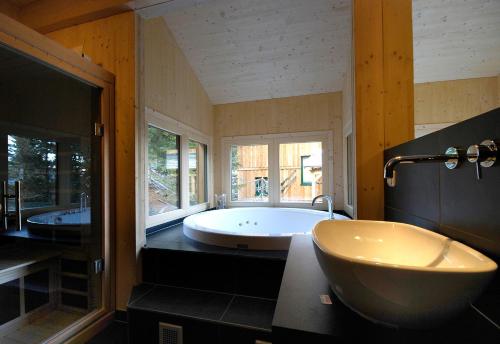 a large bathroom with a tub and two sinks at AlpenChalet ZirbenDuft in Turracher Hohe