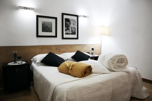 a bedroom with a bed with white sheets and pillows at Villa Alba Boutique Hotel in Pescara