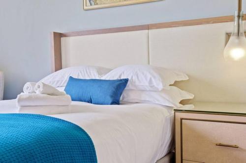 uma cama branca com almofadas azuis e brancas em Studio Located at The Ritz Carlton Key Biscayne, Miami em Miami