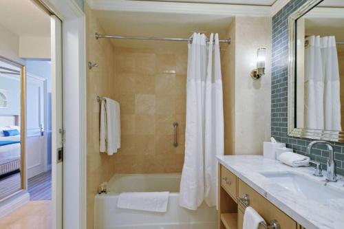 Studio Located at The Ritz Carlton Key Biscayne, Miami في ميامي: حمام مع حوض ومغسلة ومرآة