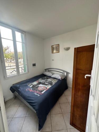 a bedroom with a bed and a window at Prdc0 in Le Blanc-Mesnil