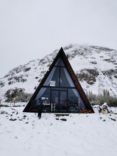 a man standing in the snow in front of a building at Loft de Montaña Único y Moderno in Esquel