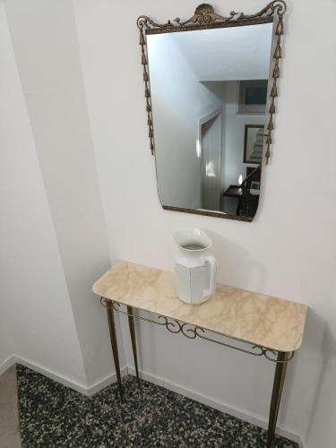 a mirror and a table with a vase on it at b&b RetrO'Conero in Castelfidardo