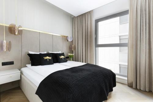 Un dormitorio con una cama en blanco y negro y una ventana en Water Harmony Chmielna en Gdansk