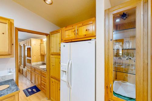 - un réfrigérateur blanc dans une cuisine avec des placards en bois dans l'établissement Bait Shop, à Carpenterville