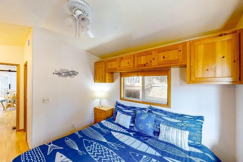 1 dormitorio con 1 cama azul y armarios de madera en Bait Shop, en Carpenterville