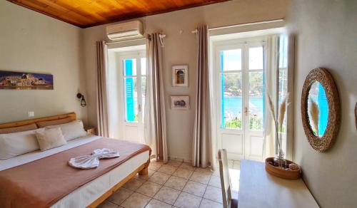 a bedroom with a bed and a large window at Seamore Pension in Galaxidi