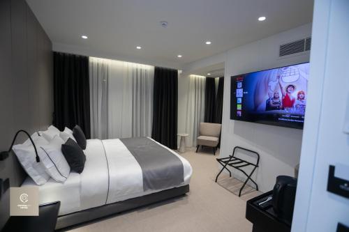 a bedroom with a bed and a flat screen tv at Central Inn Hotel in Tirana