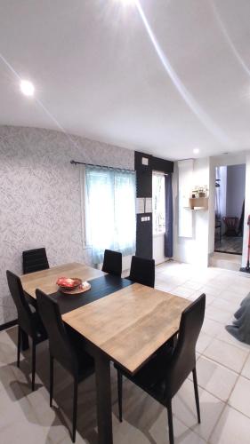 une salle à manger avec une table et des chaises en bois dans l'établissement Appartement - Parking - Wifi - 1 à 6 pers -, à Barsac