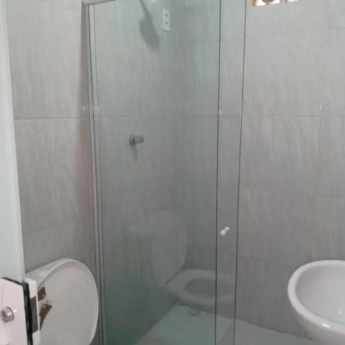 a bathroom with a shower and a toilet and a sink at Pousada da Rotatória in São Gonçalo do Amarante