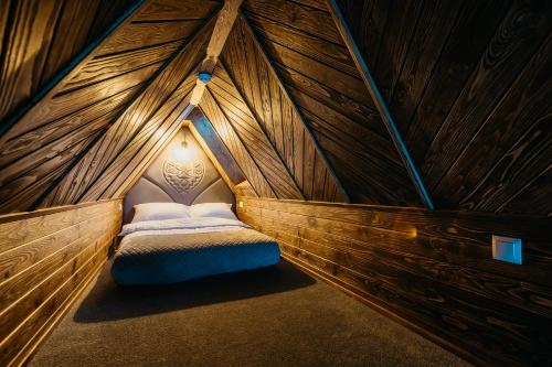 um quarto com uma cama num quarto de madeira em Domek na Wilczniku em Zakopane