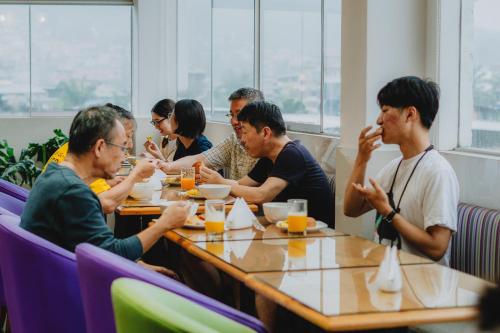 Un grupo de personas sentadas en una mesa comiendo comida en Hotel Natural Green Lounge, en Tingo María