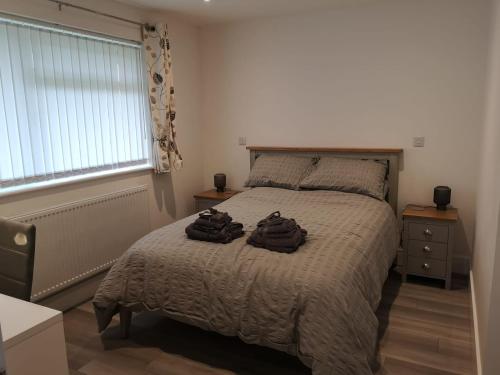 a bedroom with a bed with two bags on it at Cornish Coastal Bungalow in Padstow
