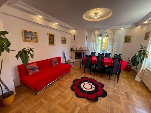 a living room with a red couch and a table at Casa Edan Breaza in Breaza