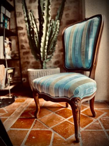 a chair with a striped seat in a room at Le Clos de L'Olivier in Chaintreaux