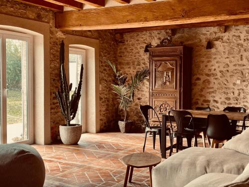 a living room with a table and chairs in it at Le Clos de L'Olivier in Chaintreaux