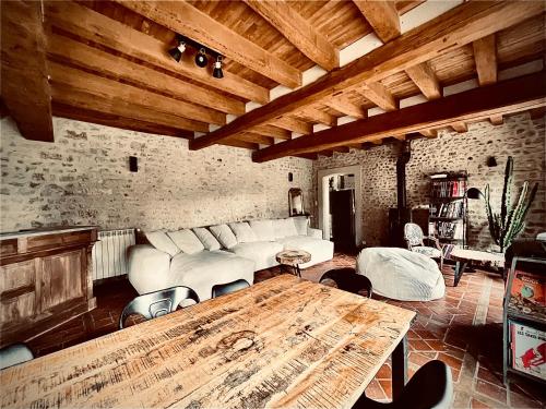 a living room with a couch and a table at Le Clos de L'Olivier in Chaintreaux